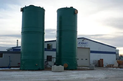 Two standing green large fiberglass tanks